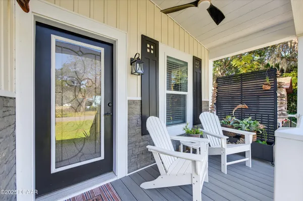 a view of a porch with furniture and wooden floor