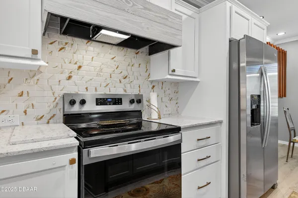a kitchen with stainless steel appliances a stove a refrigerator and cabinets