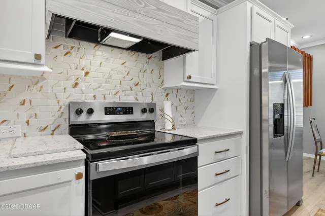 a kitchen with stainless steel appliances a stove a refrigerator and cabinets