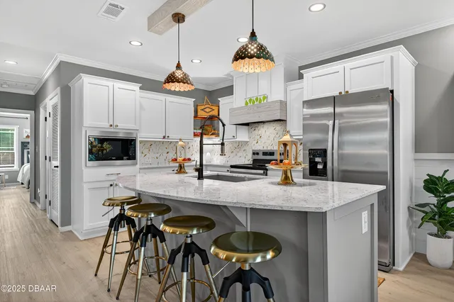 a kitchen with stainless steel appliances granite countertop a sink a stove and a refrigerator