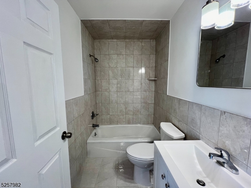61 Mountainview Boulevard, Unit 4 Wayne, NJ 07470 - Photo 4 of 8 a bathroom with a bathtub shower sink vanity and a toilet