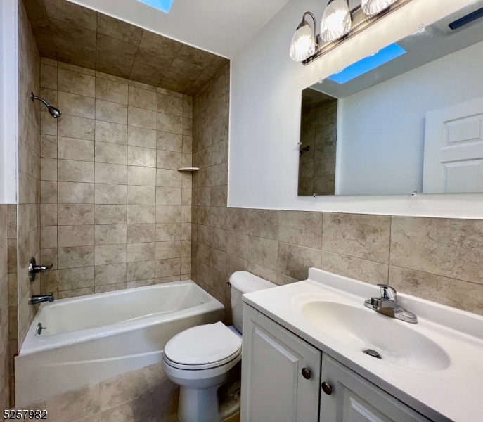61 Mountainview Boulevard, Unit 4 Wayne, NJ 07470 - Photo 7 of 8 a bathroom with a sink a toilet and bathtub
