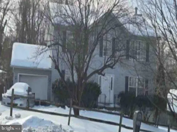 a front view of a house with a yard and tree s