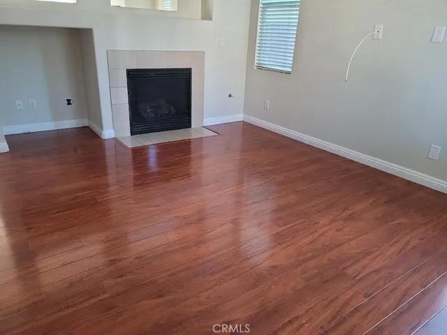 an empty room with wooden floor and fireplace