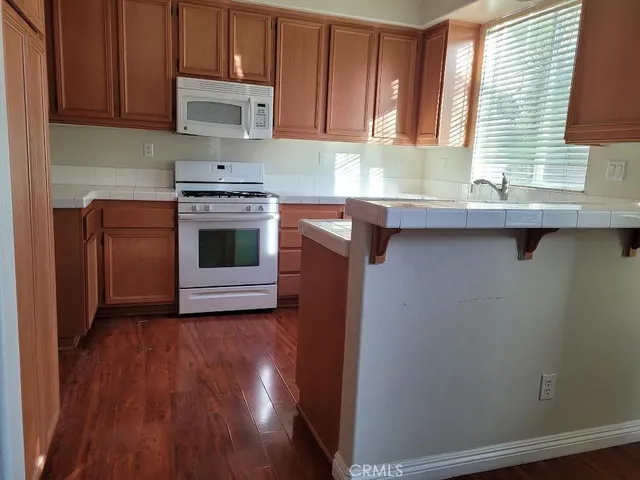 a kitchen with granite countertop a sink cabinets and stainless steel appliances