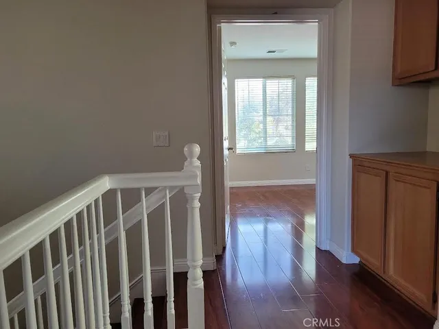 a view of a hallway with wooden floor and a window