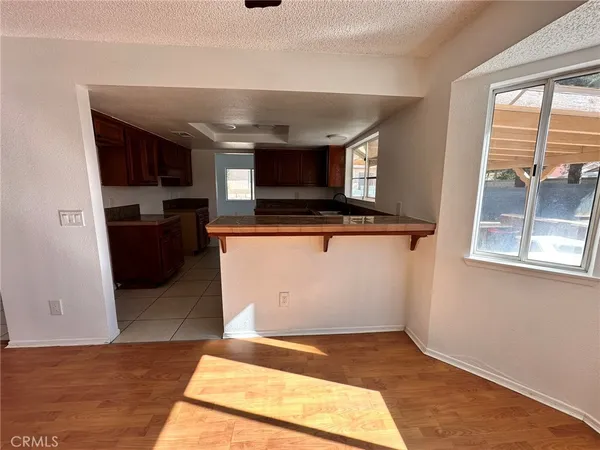a view of living room with stainless steel appliances wooden floor and window