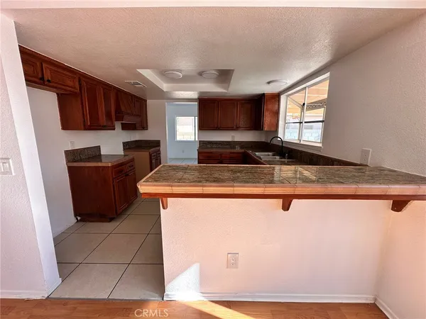 a kitchen with kitchen island granite countertop a sink cabinets and a counter top space