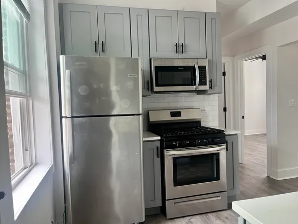 a kitchen with stainless steel appliances granite countertop a refrigerator and a stove top oven