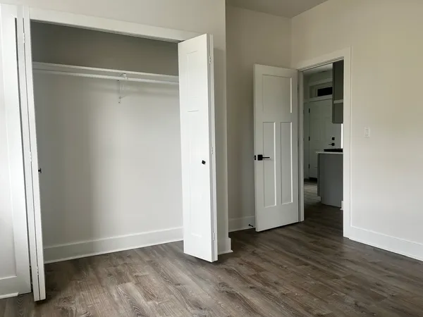 an empty room with wooden floor and closet