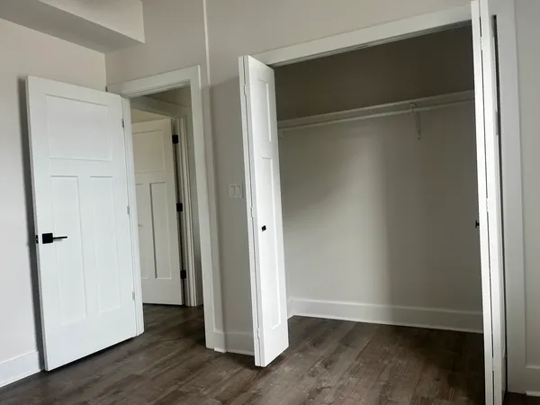 an empty room with wooden floor and closet