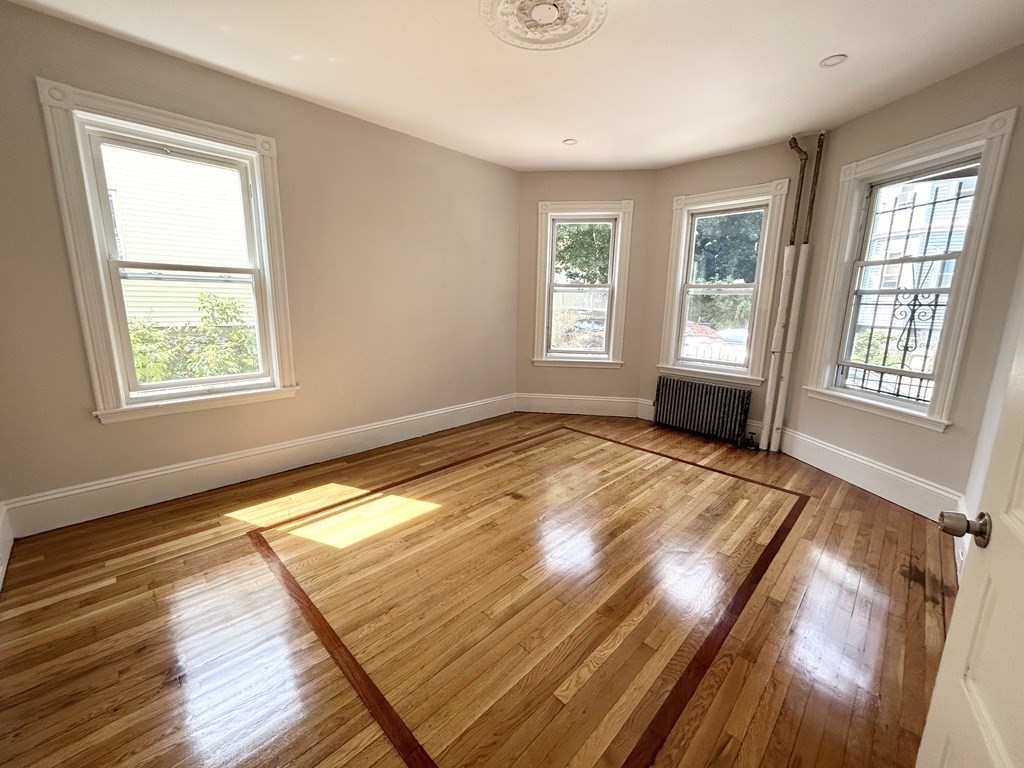 22 Humphreys Street, Unit 1 Boston, MA 02125 - Photo 3 of 6 a view of an empty room with wooden floor and a window