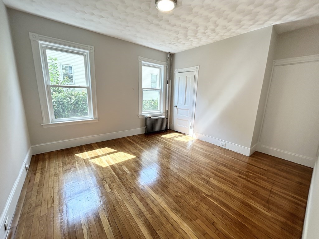 22 Humphreys Street, Unit 1 Boston, MA 02125 - Photo 4 of 6 an empty room with wooden floor and windows