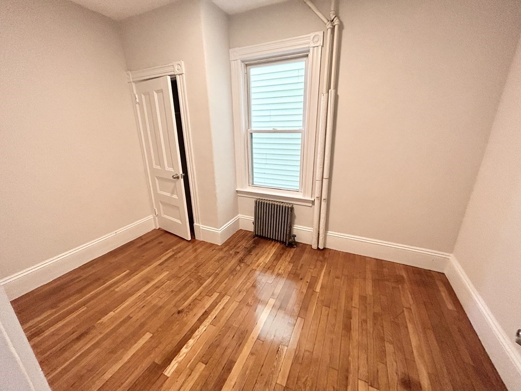 22 Humphreys Street, Unit 1 Boston, MA 02125 - Photo 5 of 6 an empty room with wooden floor and a window