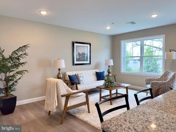 a living room with furniture potted plant and window