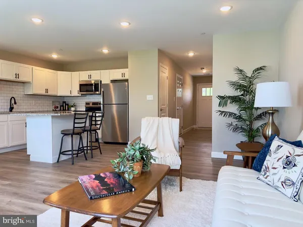 a living room with furniture and kitchen view