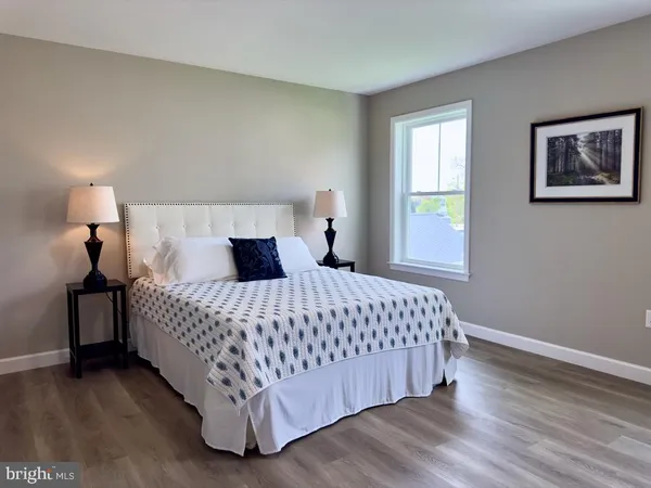 a bedroom with a bed and painting on the wall
