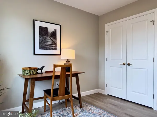 a view of room with workspace and wooden floor