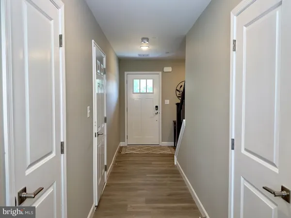 a view of a hallway with wooden floor and stairs
