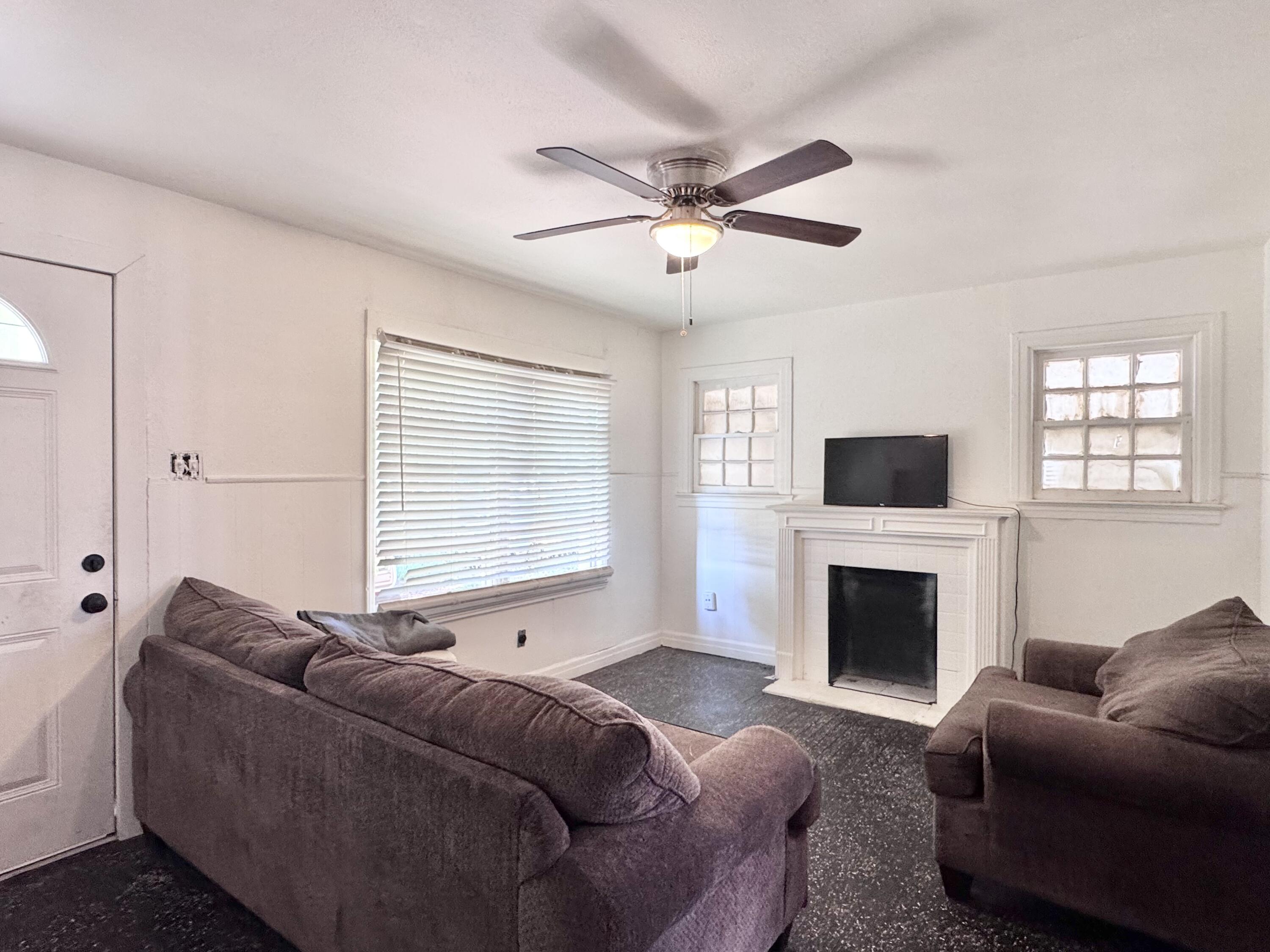 2912 Amherst Street Lubbock, TX 79415 - Photo 3 of 10 a living room with furniture a flat screen tv and a fireplace