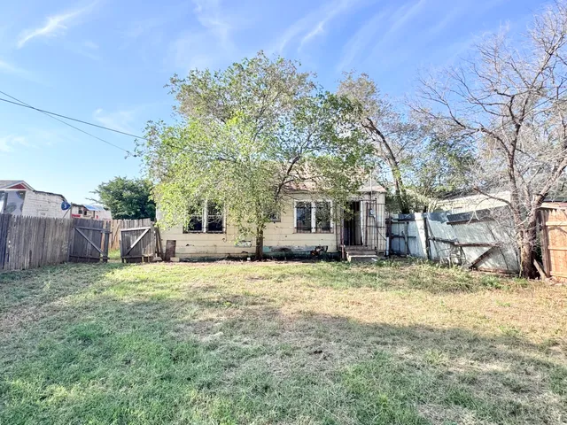 a view of a house with a yard and trees