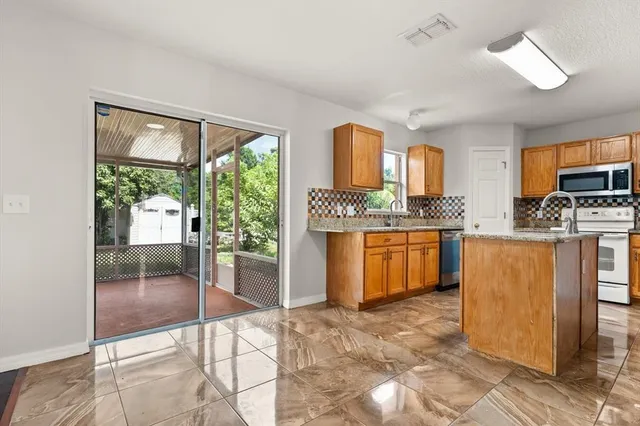 a kitchen with stainless steel appliances granite countertop a stove a sink dishwasher and a refrigerator