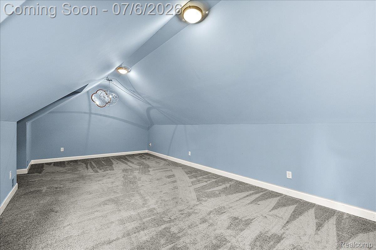 1051 Devonshire Road Grosse Pointe, MI 48230 - Photo 59 of 98 Spacious room featuring sloped ceilings, two flush-mount ceiling lights, and a decorative pendant light