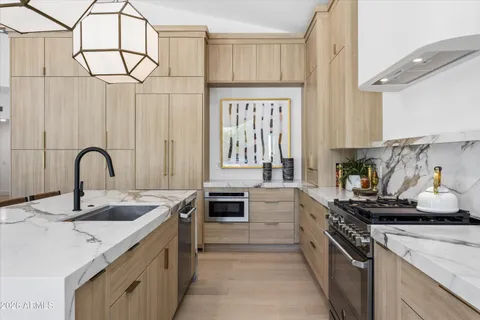 a kitchen with granite countertop a sink stainless steel appliances and cabinets