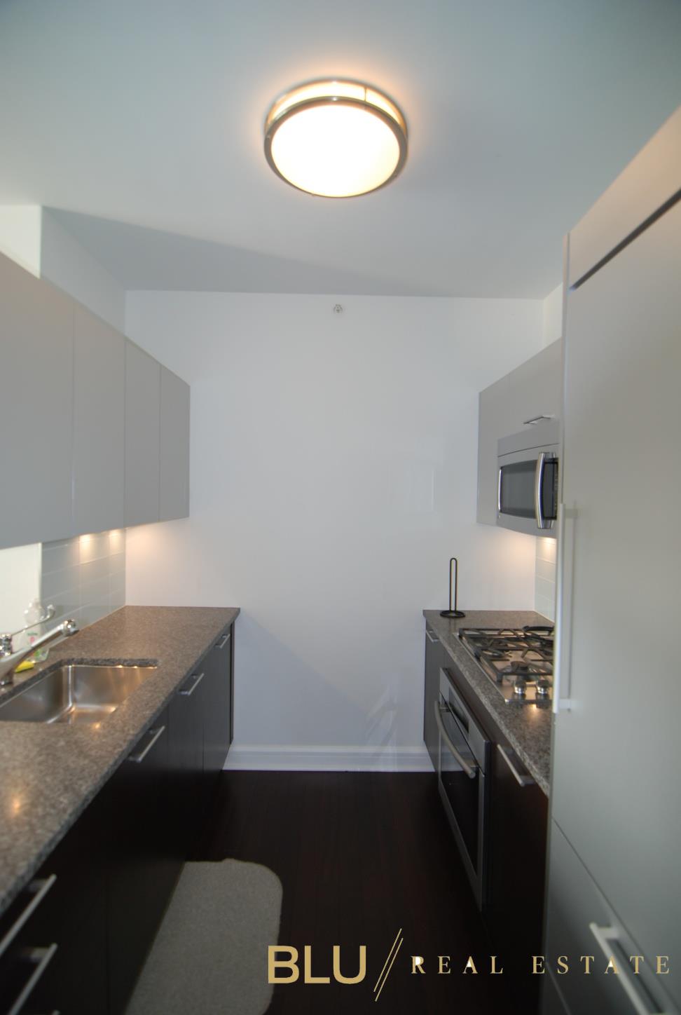 100 Riverside Boulevard, Unit 16E Manhattan, NY 10069 - Photo 6 of 11 a view of a kitchen with a sink and a stove top oven
