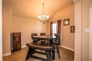 1409 Rosson Road Little Elm, TX 75068 - Photo 20 of 34 Vaulted ceiling dining area featuring tile flooring, a window with red drapes, and a chandelier light fixture