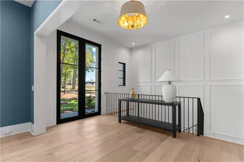 a dining room with wooden floor a chandelier a wooden table and chairs