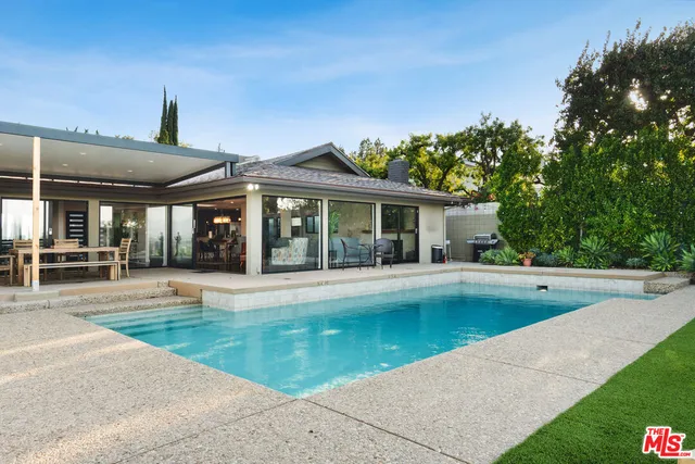 a view of a house with swimming pool and a yard