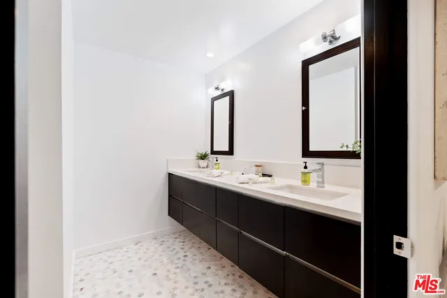 a bathroom with a double vanity sink and mirror