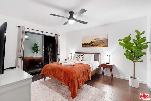 a bedroom with a bed table and a potted plant