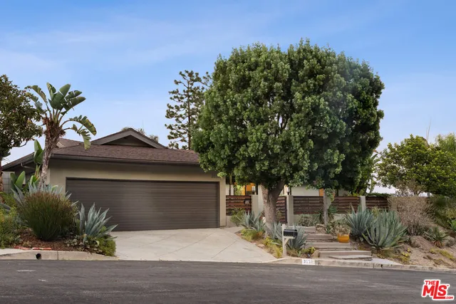 a front view of a house with a yard garage and outdoor seating