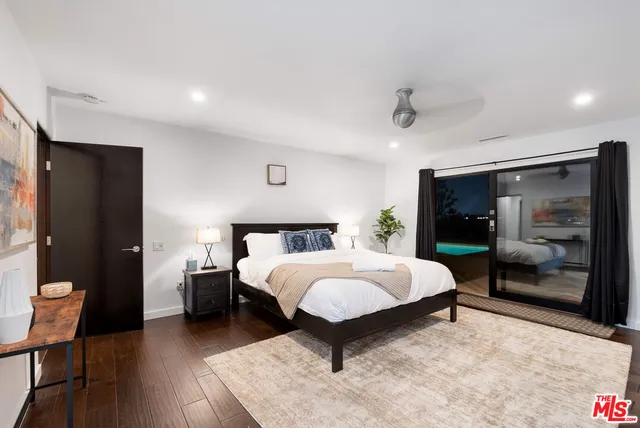 a spacious bedroom with a bed and a flat screen tv