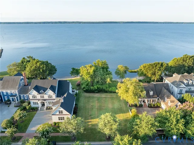 an aerial view of a house with a yard and lake view
