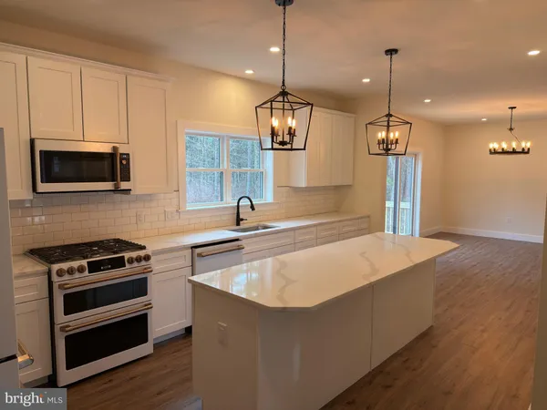 a large kitchen with kitchen island a sink stainless steel appliances and cabinets