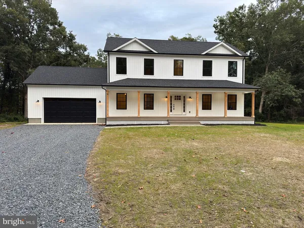 a front view of a house with yard and trees
