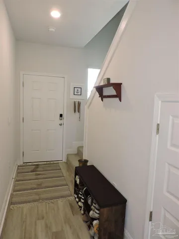 a view of a hallway with wooden floor and staircase
