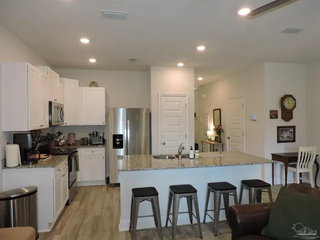 a kitchen with stainless steel appliances granite countertop a stove a sink a refrigerator and a refrigerator