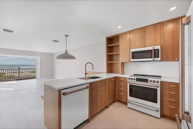 a kitchen with stainless steel appliances a stove a sink and a microwave
