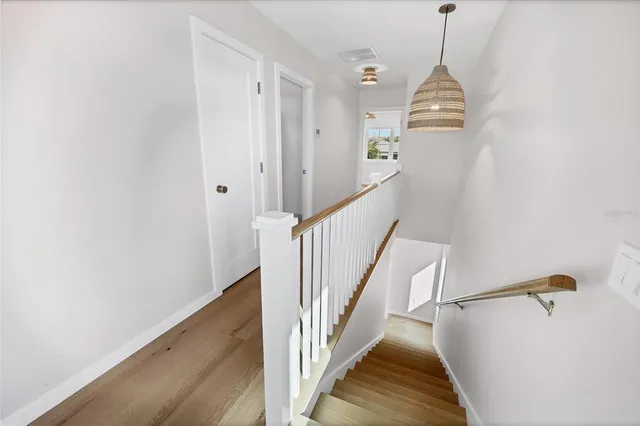 a view of a hallway with wooden floor and staircase