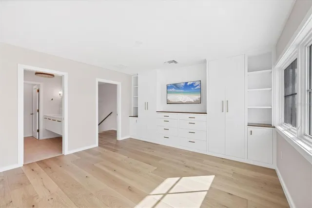 a view of a bedroom with wooden floor and cabinet