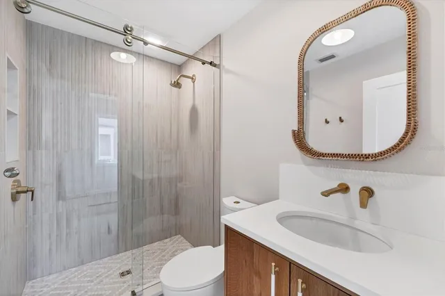 a bathroom with a sink a toilet and shower