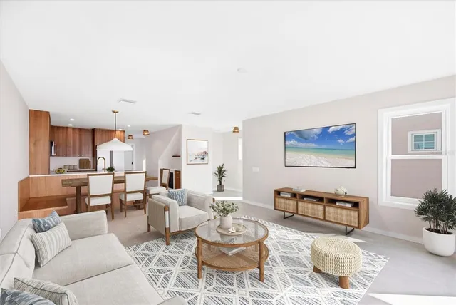 a living room with furniture and a dining table with kitchen view