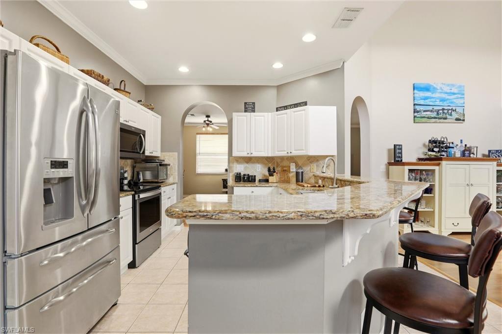 21524 Windham Run Estero, FL 33928 - Photo 16 of 50 a kitchen with stainless steel appliances granite countertop a sink refrigerator and cabinets