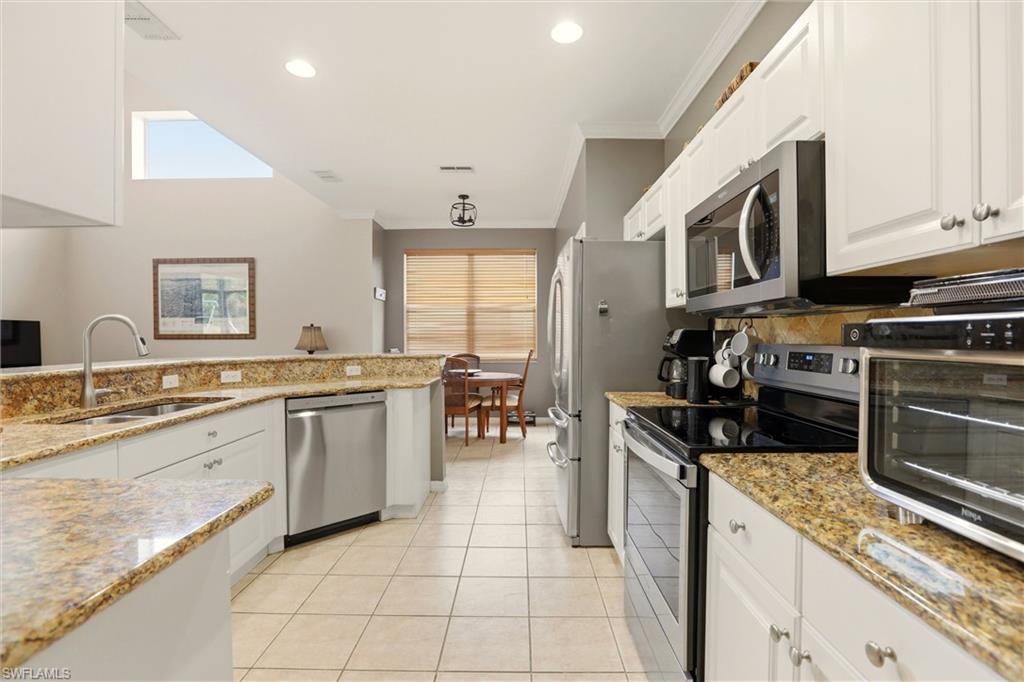 21524 Windham Run Estero, FL 33928 - Photo 22 of 50 a kitchen with stainless steel appliances granite countertop a stove a sink and a microwave