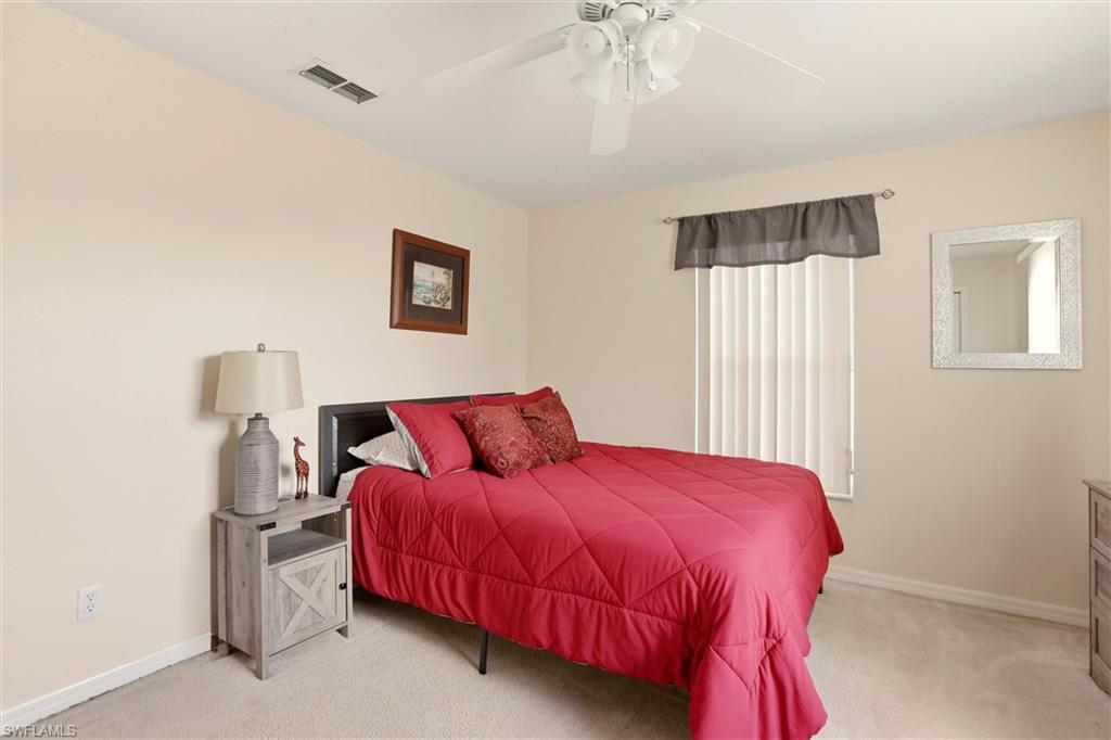 21524 Windham Run Estero, FL 33928 - Photo 26 of 50 a bedroom with a bed and a chandelier