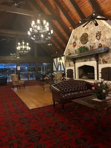 a living room with furniture a chandelier and a fireplace